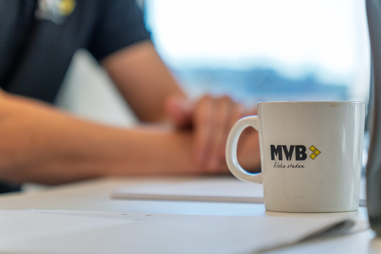 Man vid skrivbord med MVB-mugg